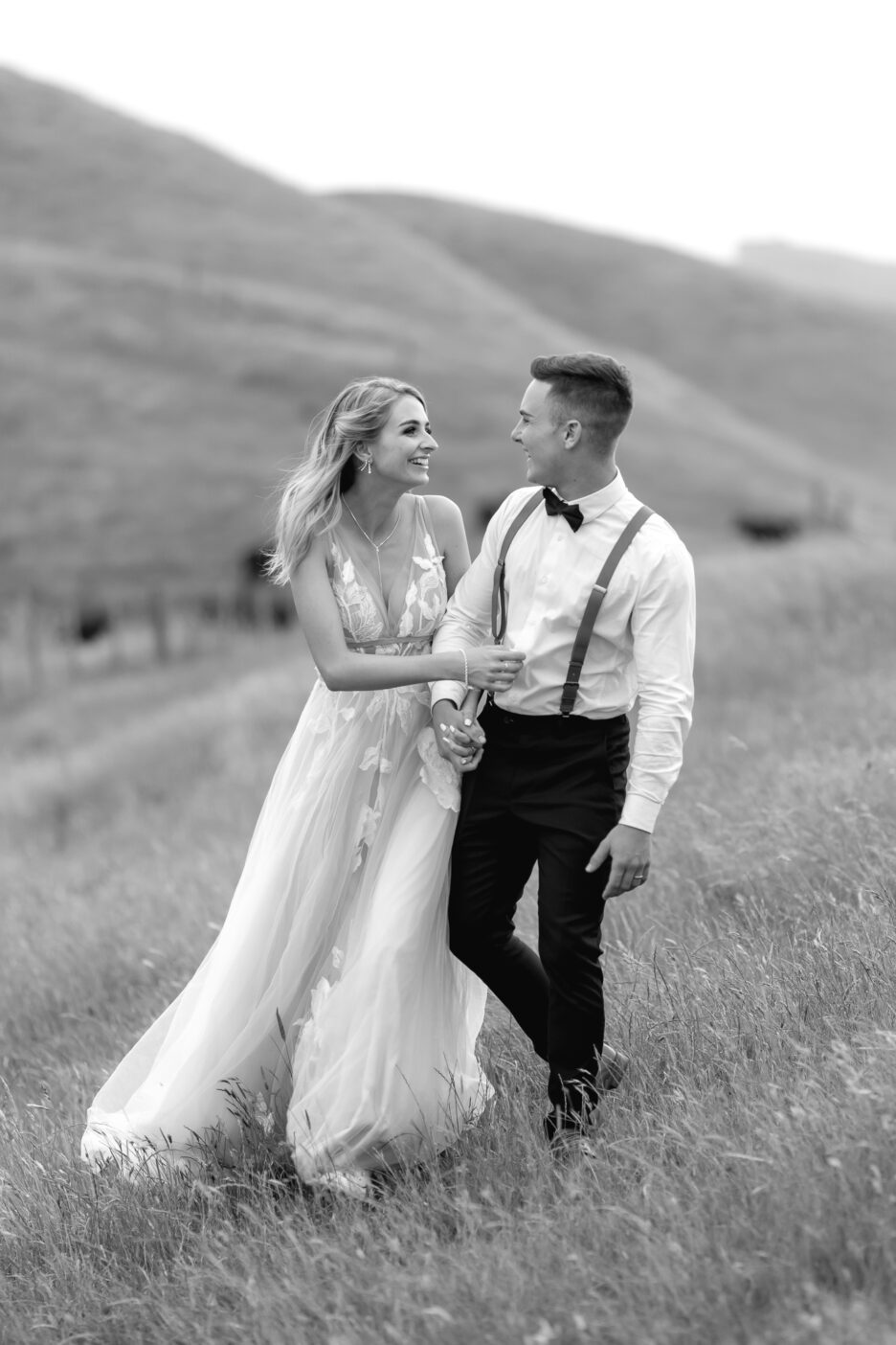 Hawkes Bay Waiterenui farm wedding couple walking in hills laughing during their photography