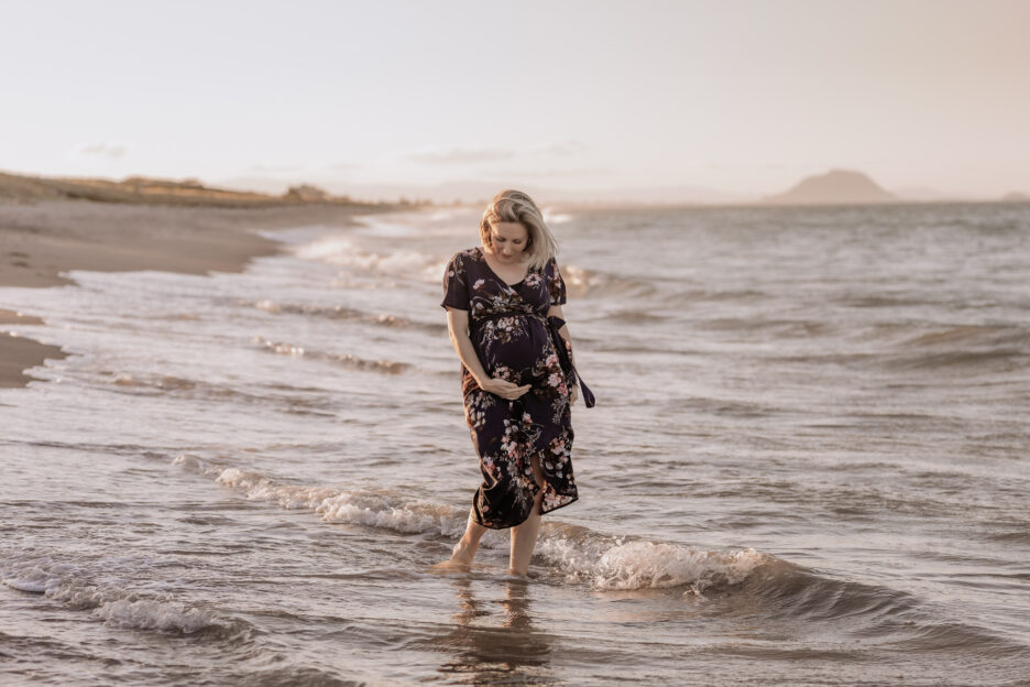 Maternity shoot of Mum walking in golden hour in the waters at Papamoa beach