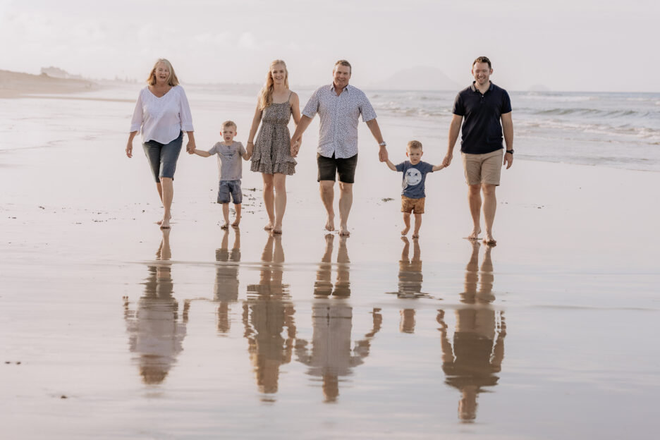 Papamoa family walking on beach during photos