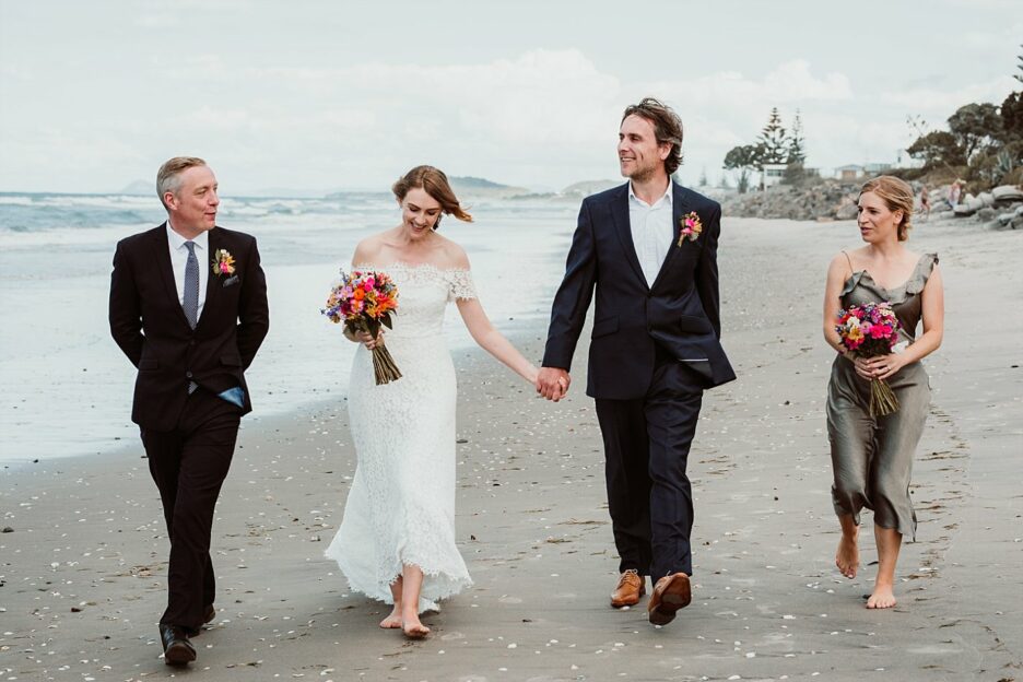 Wedding party walking the beach at Waihi