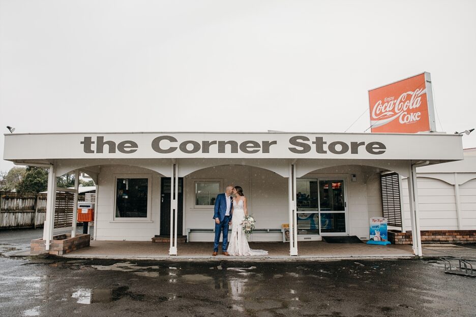 Vintage Corner store on the Coromandel with Bride and groom kissing