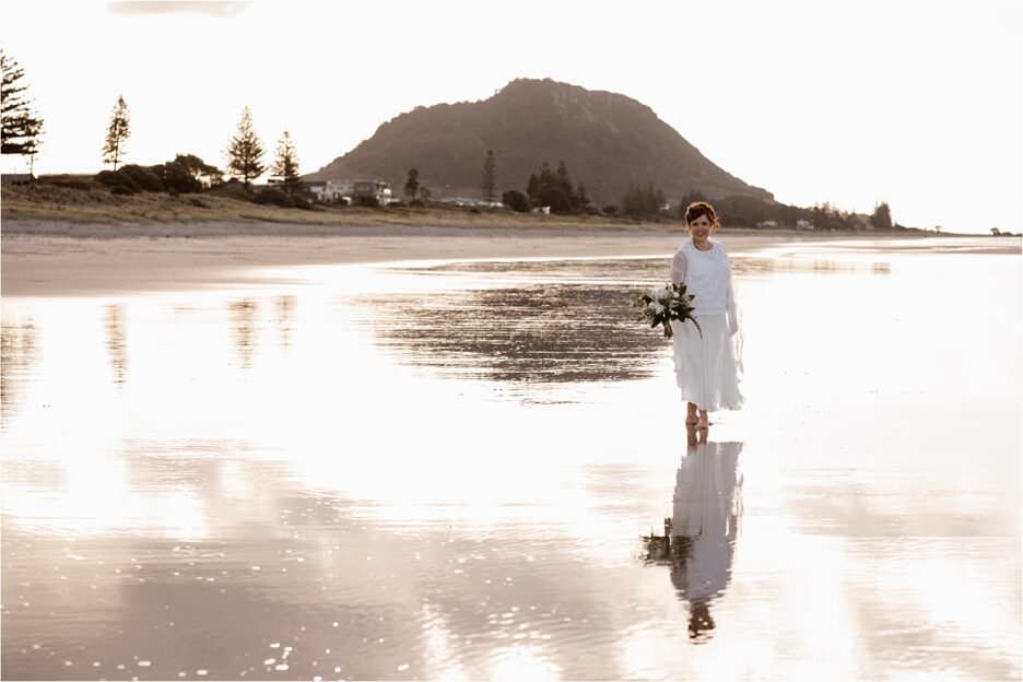 Bride on beach in golden light at Mount Maunganui
