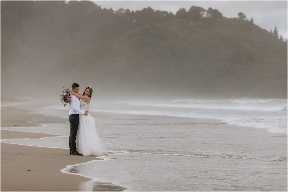 Happy couple with waves on Waihi Beach
