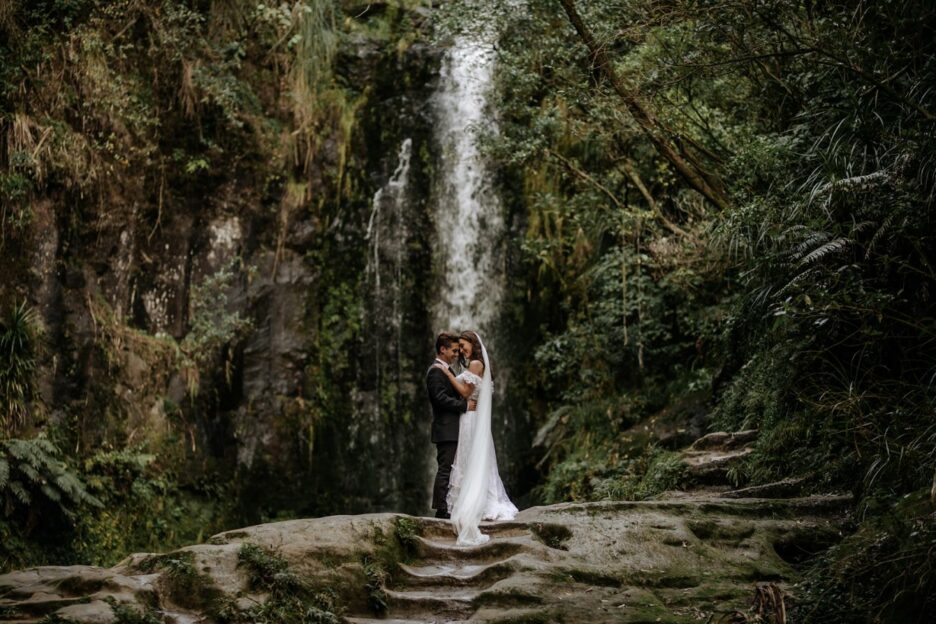 Beautiful moment in front of waterfall with bride and groom in NZ