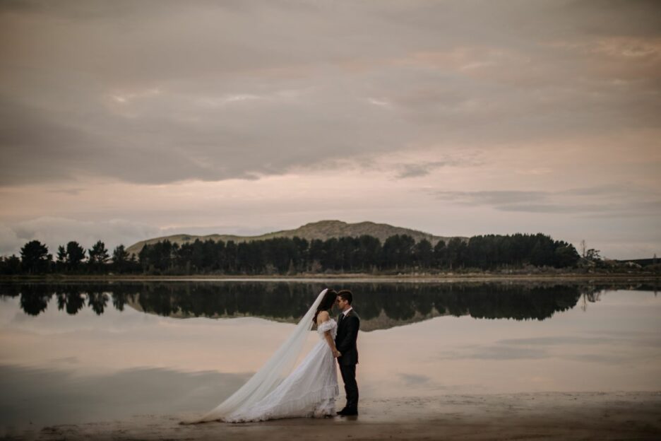 Reflections by the water in Tauranga New Zealand with elopement couple
