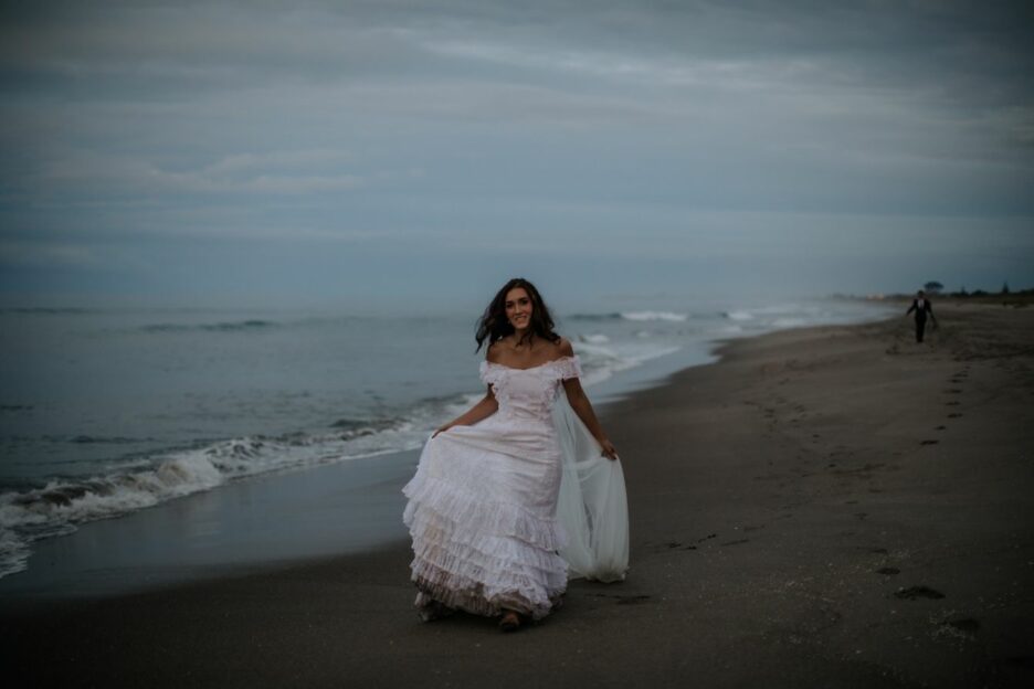 Bride walking in her boho vintage wedding dress on the beach