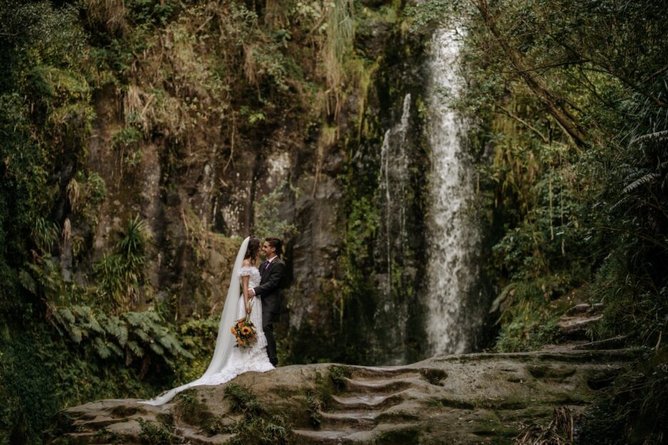 Elopement couple in front of waterfall Tauranga New Zealand