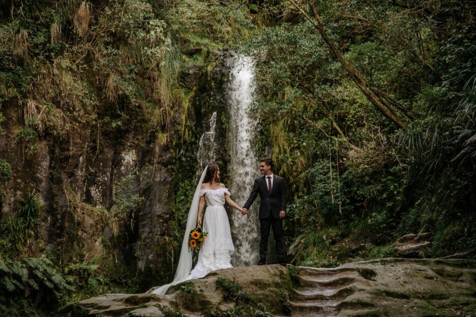 Vintage photo of bride and groom in front of waterfall