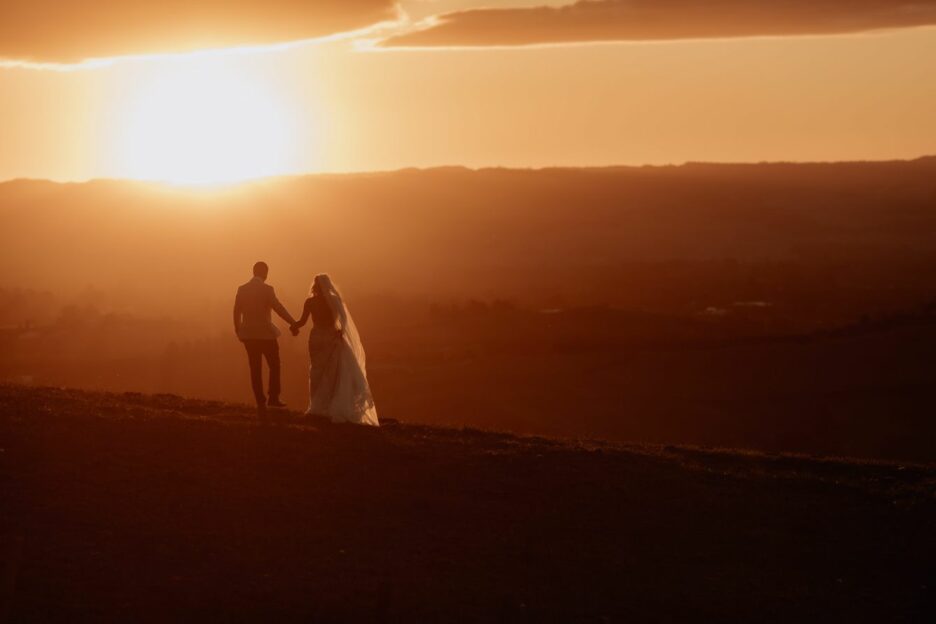 Bride and groom walking away during the sunset