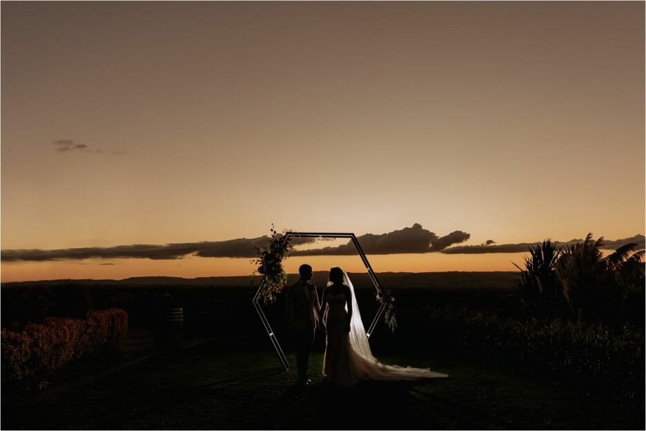Sunset photo under wedding arch