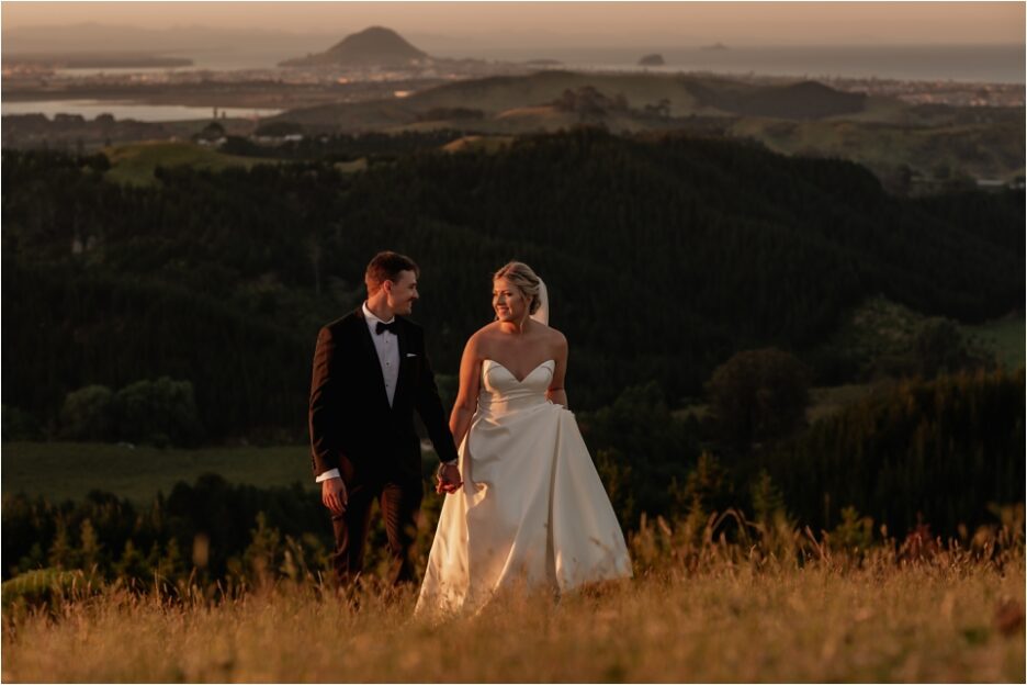 Wedding Photos walking the hills above Tauranga with Mount Maunganui scene