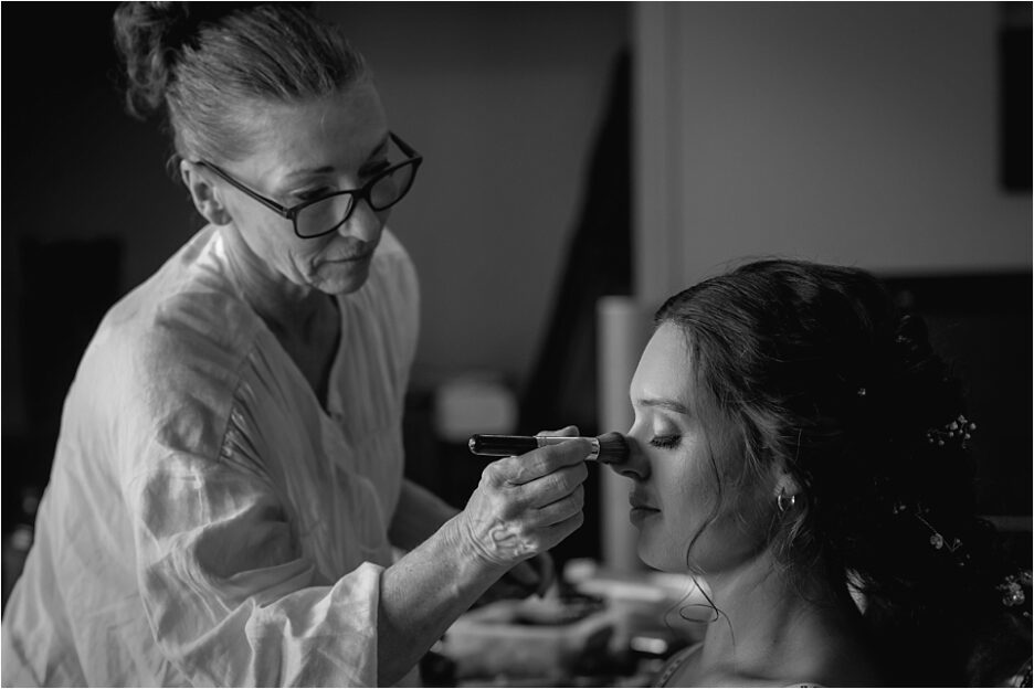Wedding hair and makeup artist working on bride