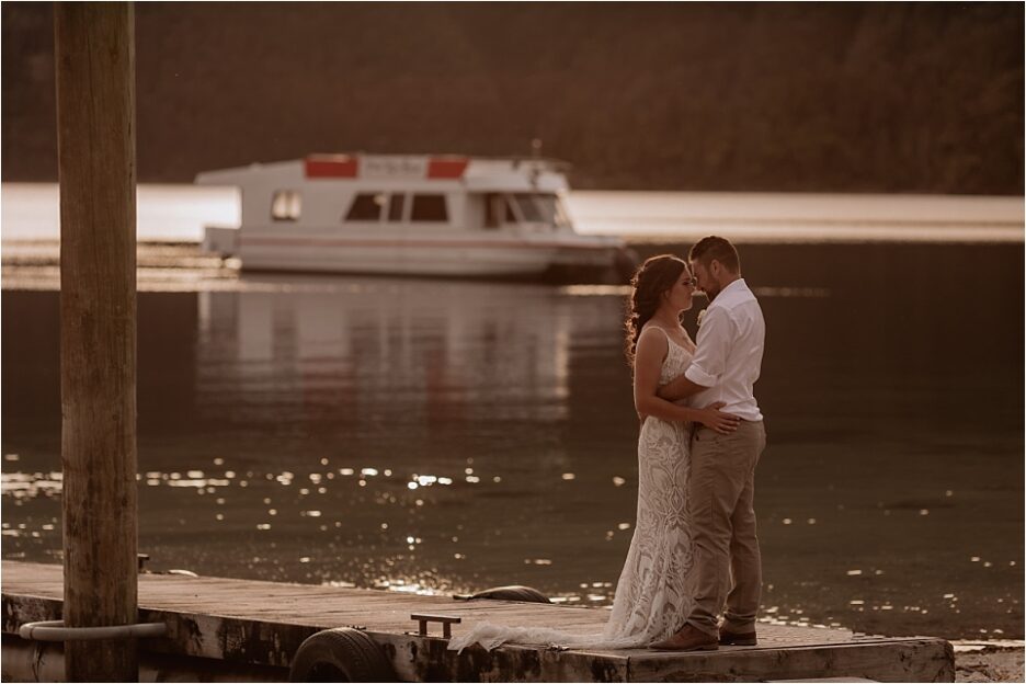 Wedding couple at Lake Okataina pier with 70's boat in the water