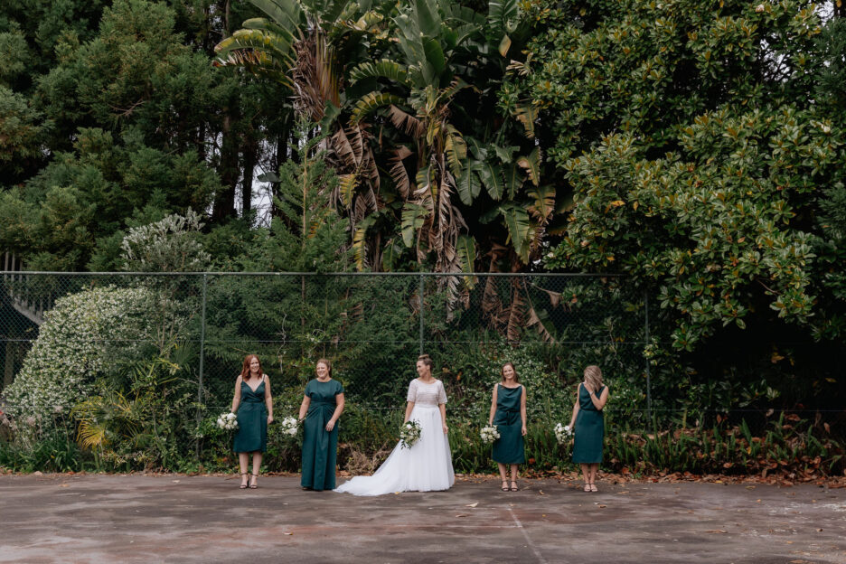 Bride with bridesmaids on tennis court