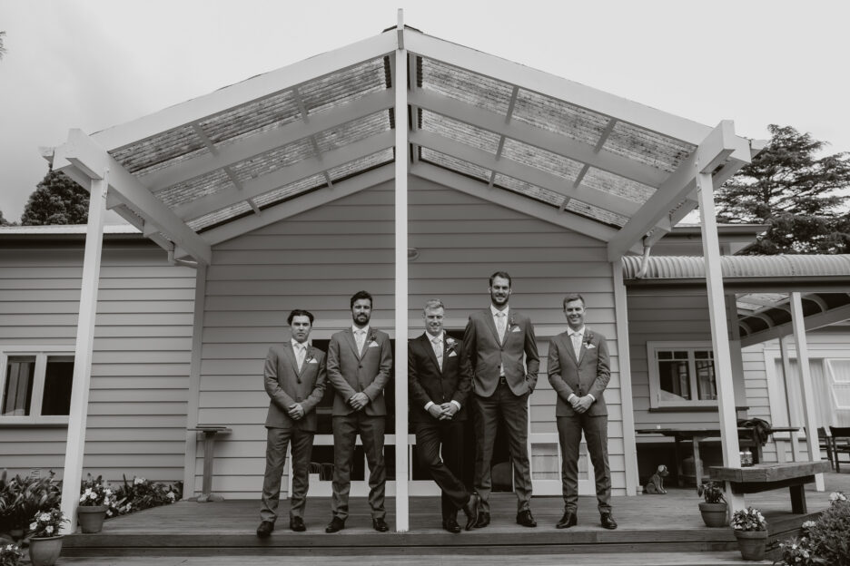 Groom with groomsmen in front of house