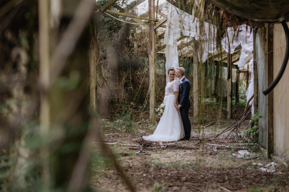 Bride and groom in old abandoned glass house