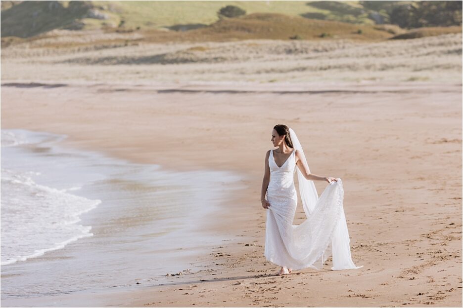 Bride walking beach in Felicity bridal gown