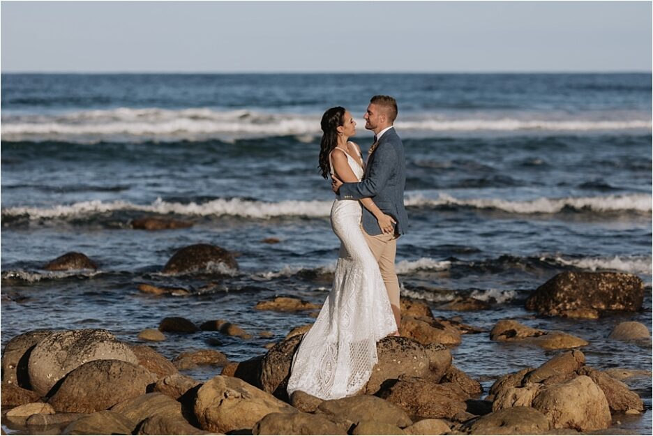 Wedding photos on rocks at Orua beach house