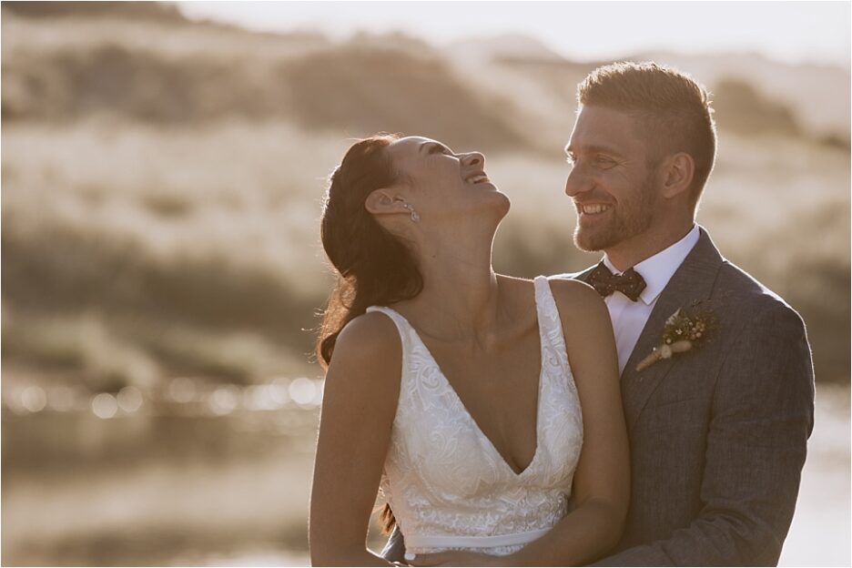 Bride laughing in golden light on Hot water beach