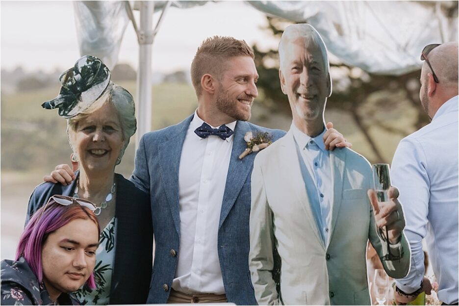 Groom with cut out of parents at his wedding