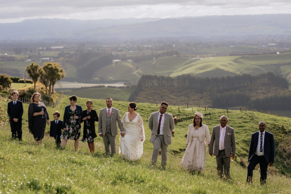 All wedding guests walking together up hill