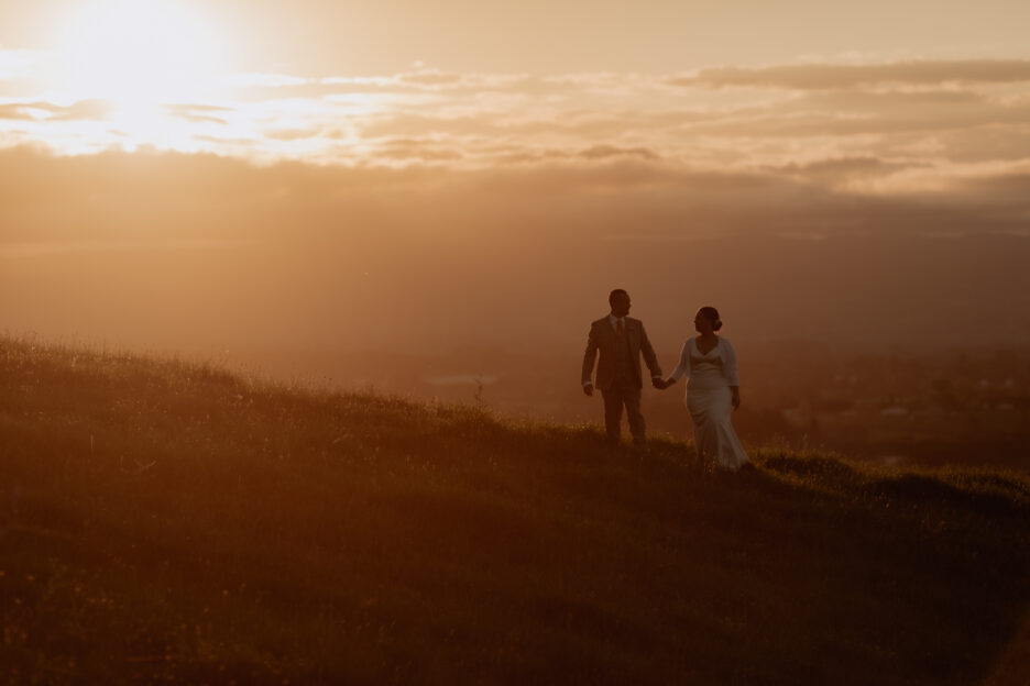 Sunset wedding photography of couple walking ridge line