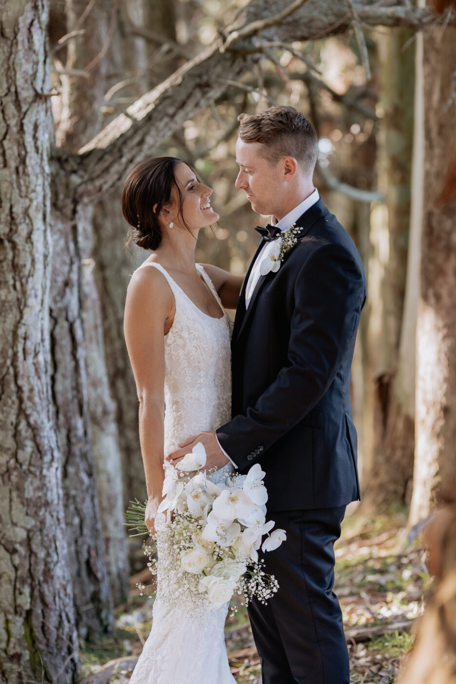 Bridal couple looking at each other in tree tunnel