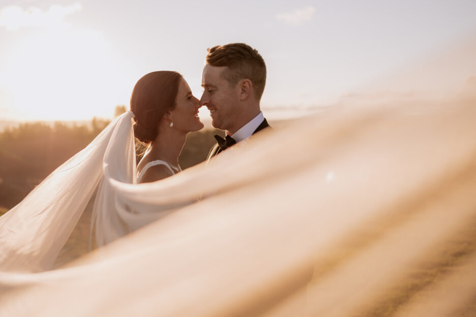Couple with veil wrapped around them