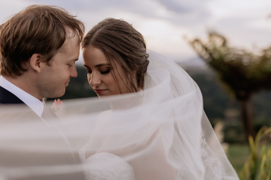 bride and groom under windy veil