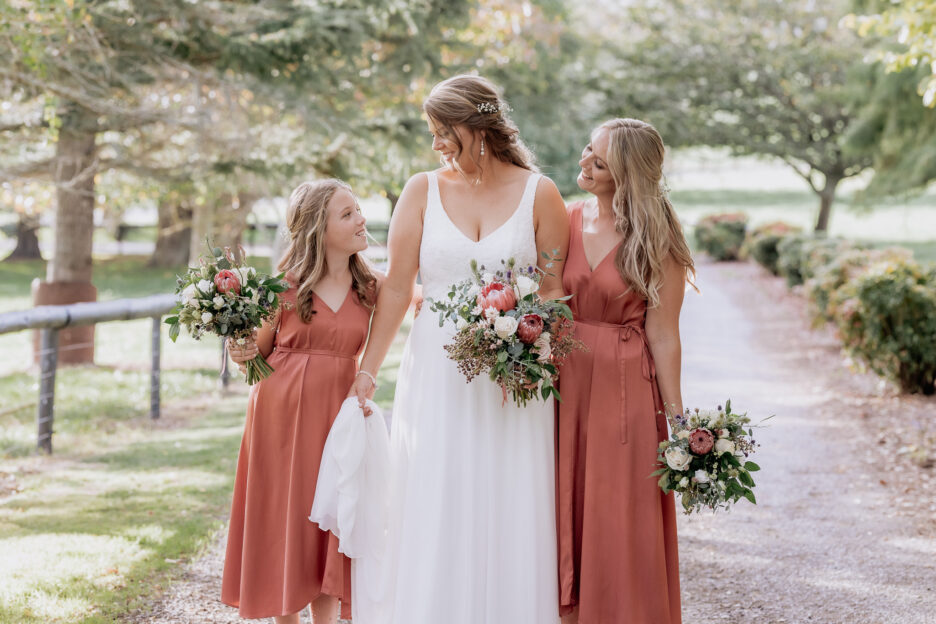 bride with bridesmaid and flower girl in rust coral dresses