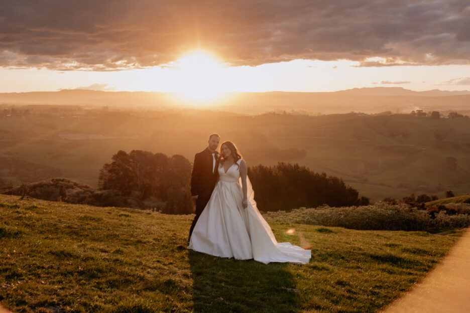 bride and groom looking at camera as sunsets