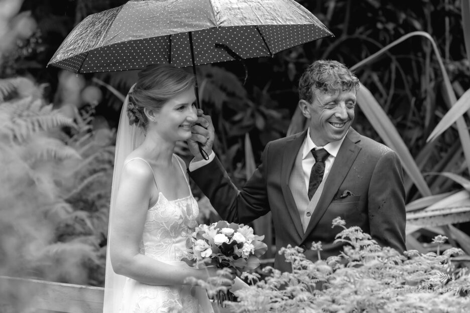 happy smiling Bride and groom getting married in the rain