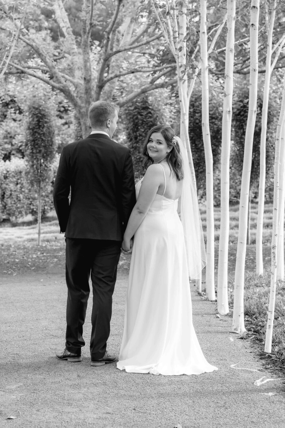 Bride turns to look at wedding photographer Ohaupo Tree church gardens