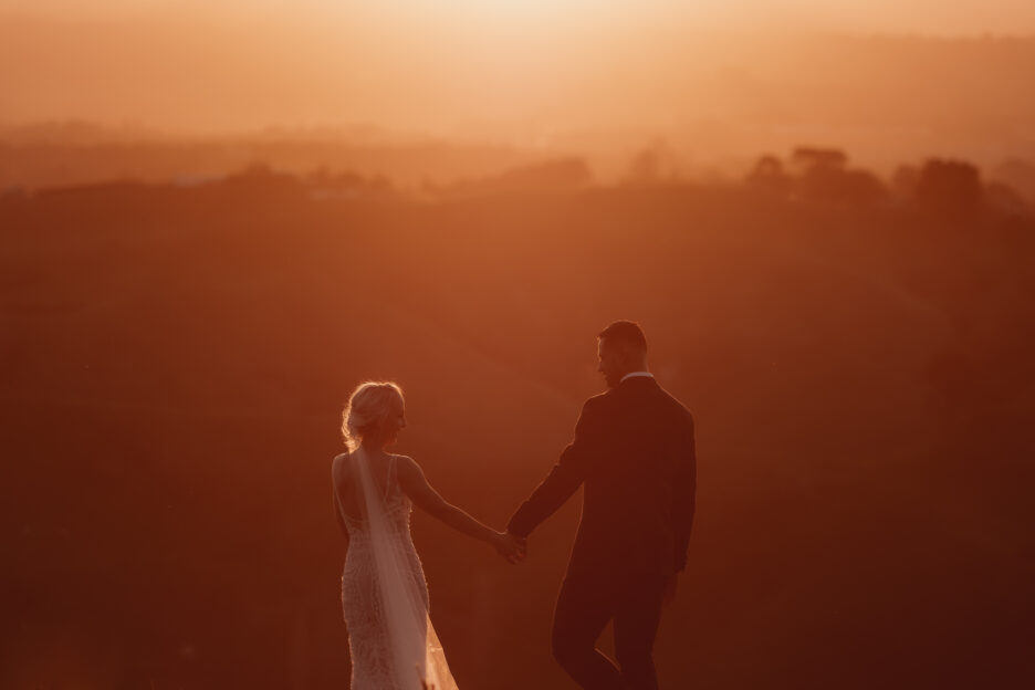 Beautiful golden moment of couple walking at sunset in the hills