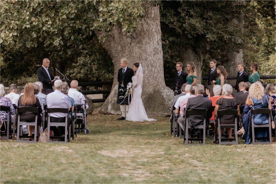 Wedding ceremony under tree at Red Barn