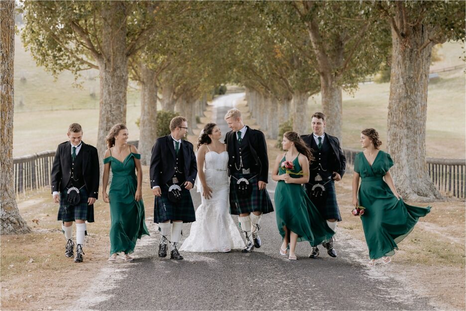 beautiful scottish wedding party walking on red barn driveway