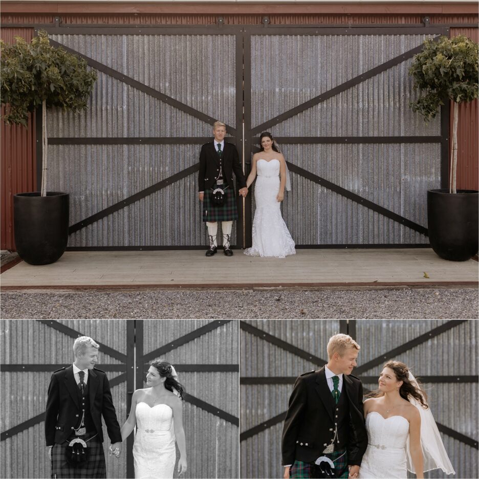 Bride and groom standing outside red barn doors