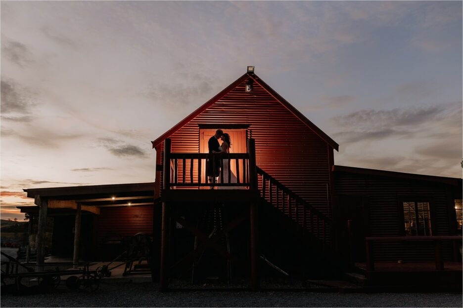 Red barn with couple back lit upstairs night image