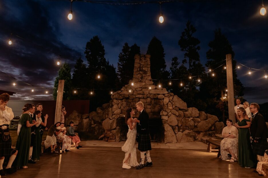 first dance for bride and groom outside under chimney and fairy lights