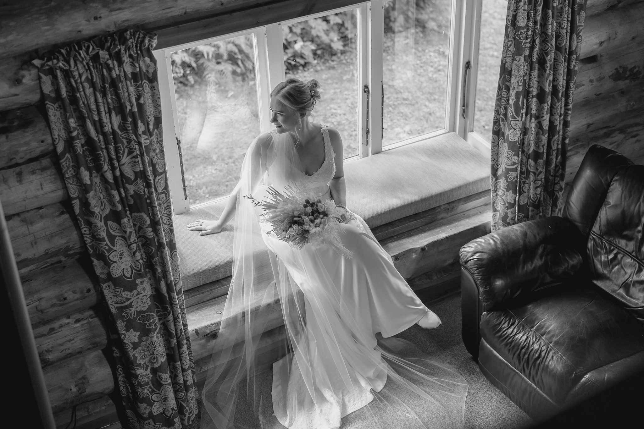 Bride in window of log cabin