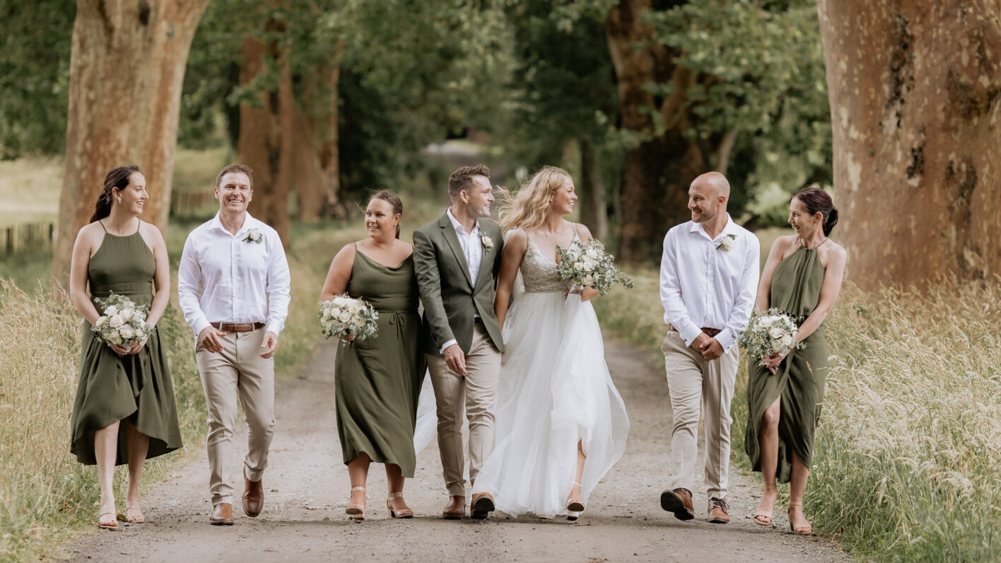 Olive green wedding party walking laughing driveway Longfords estate