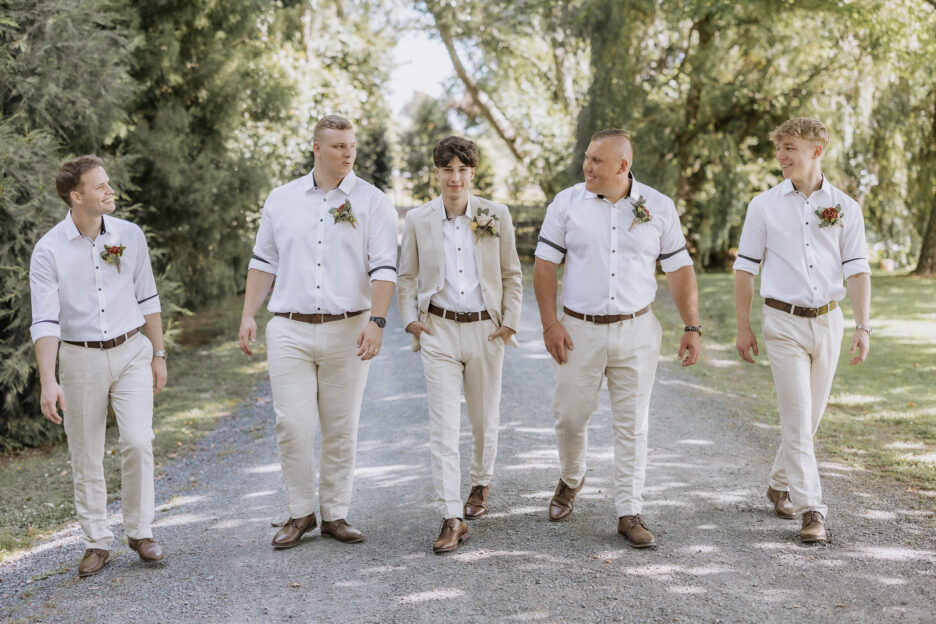 groomsmen linen suits walk with groom tree church garden wedding