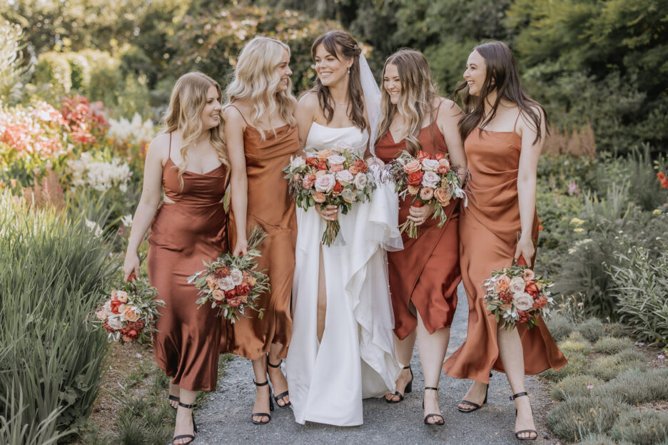 bride walking in Old Tree church garden with bridesmaids