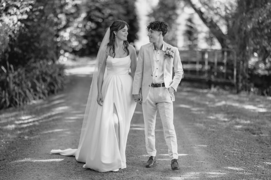 wedding couple walk gardens at Tree Church driveway