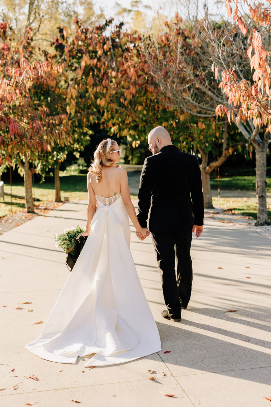 bride and groom walking driveway Black Walnut in autumn colours