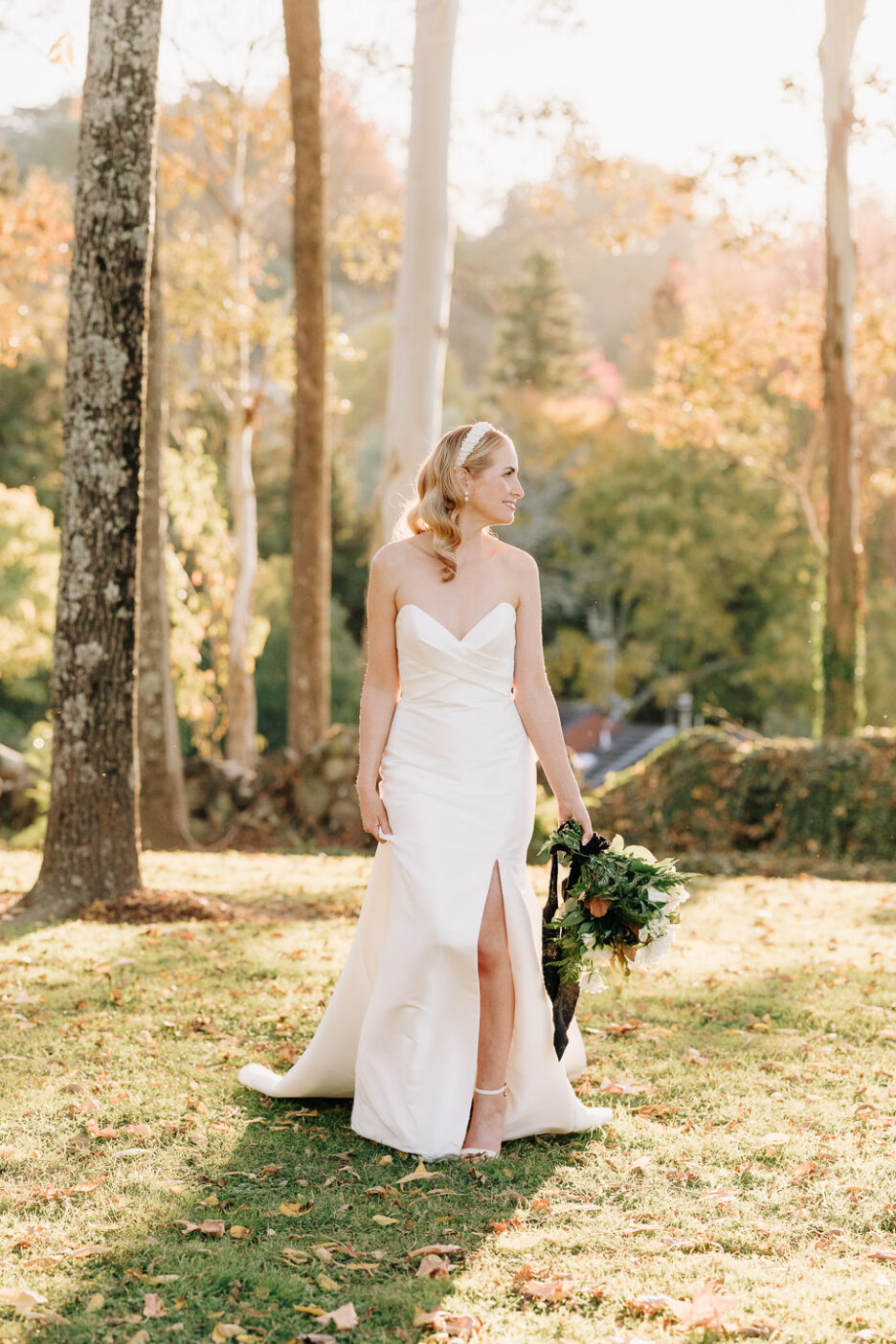 bride in astra bridal gown with bow on dress walking in golden hour light through gardens Black Walnut wedding venue