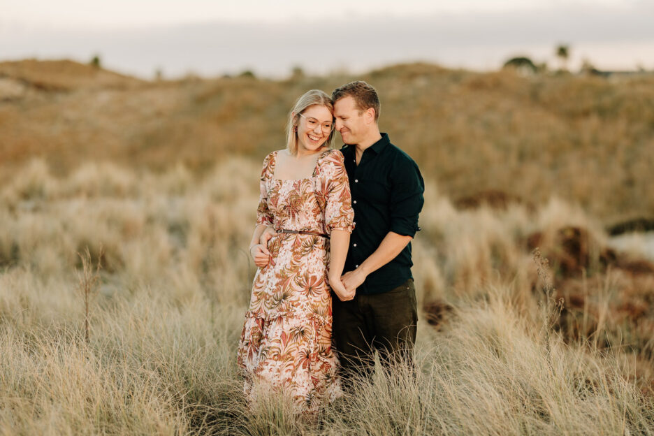 cuddling photo at engagement shoot on Papamoa sand dunes