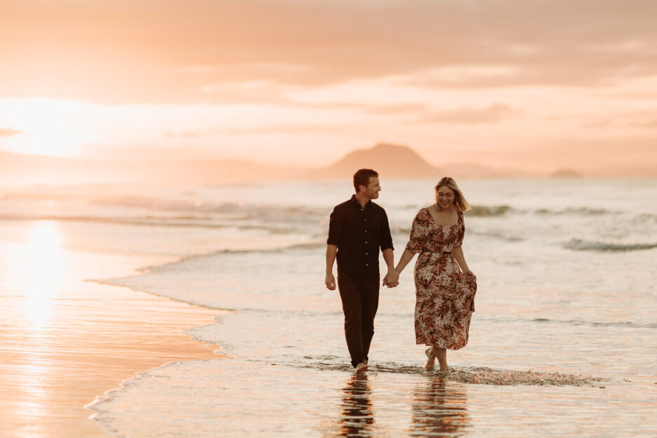 walking in the waves Papamoa beach engagement session photos