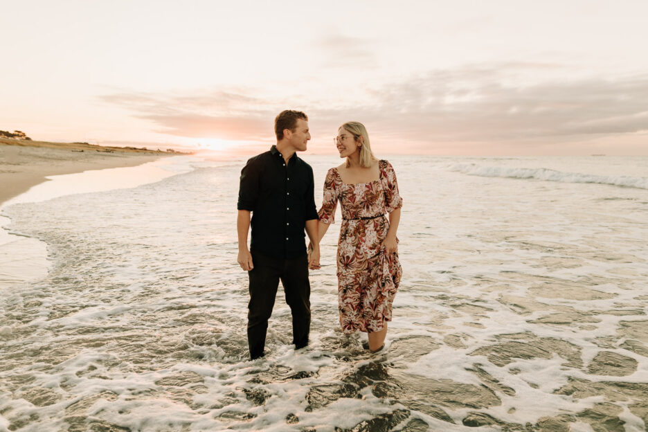 couple standing in the sea Papamoa beach engagement session photos with Pure Images Photography