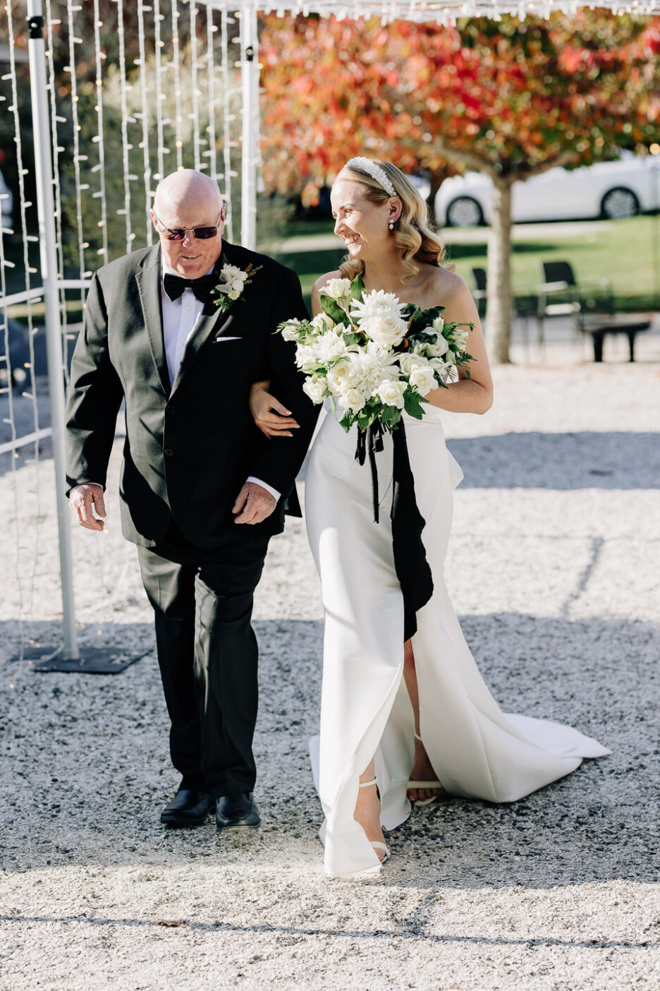 bride with father of bride walking into wedding ceremony